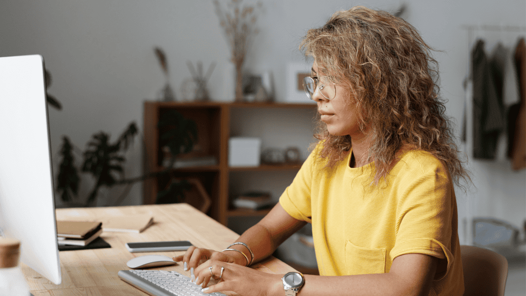 Woman working on a computer in a modern office setting.