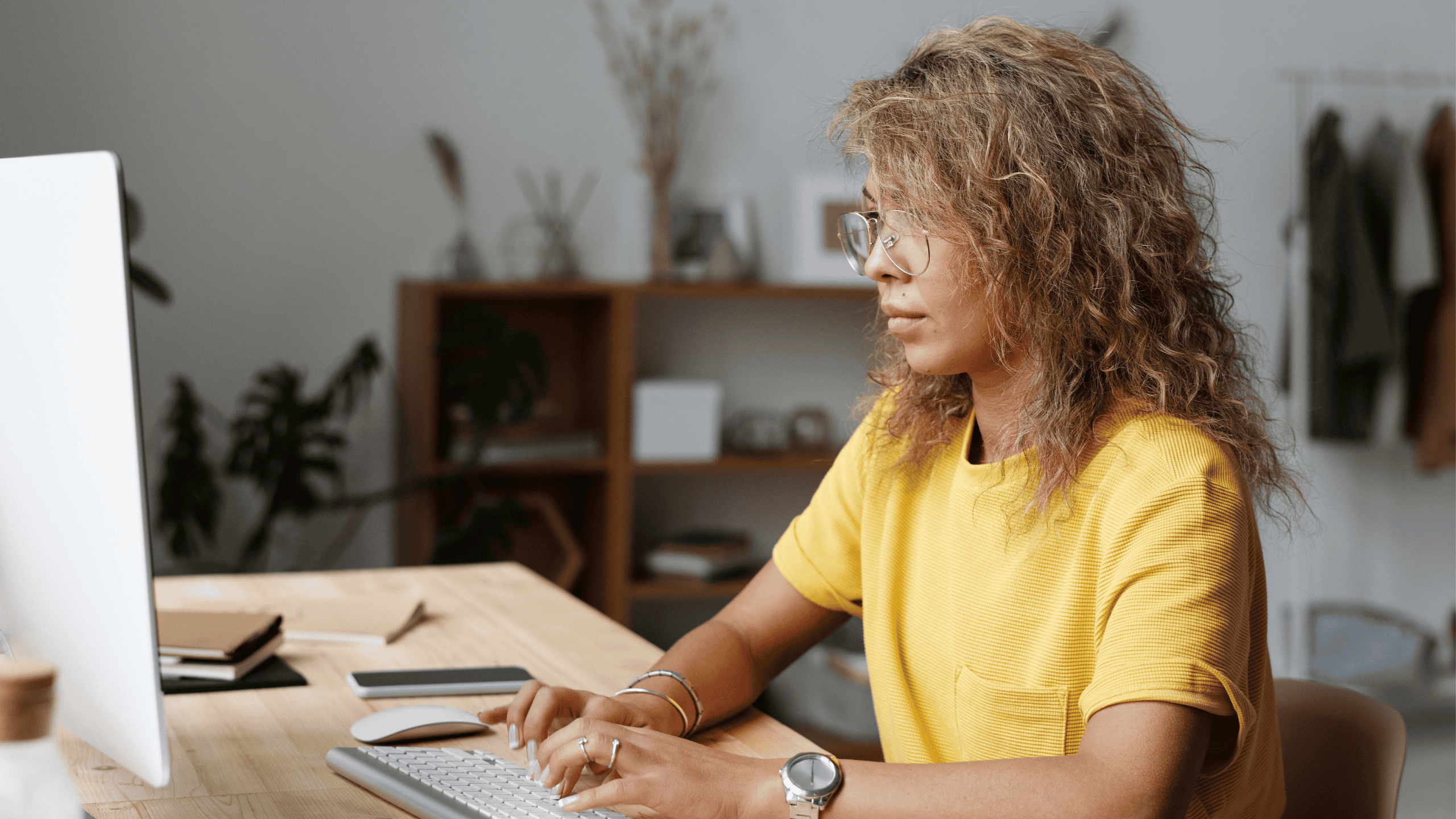 Woman working on a computer in a modern office setting.