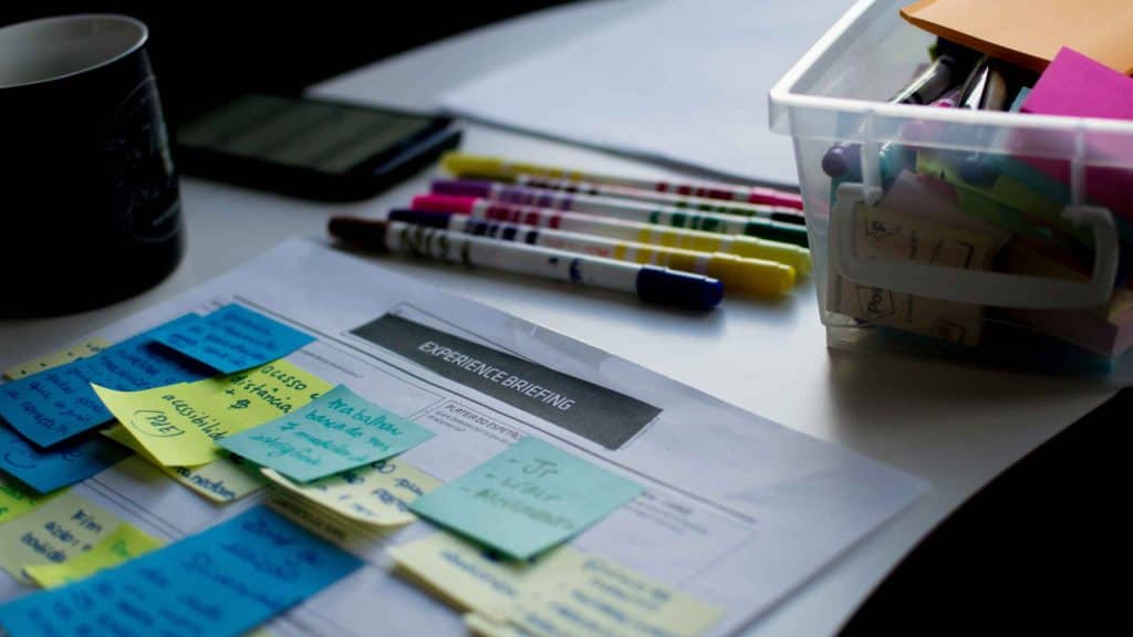 Organised workspace with sticky notes, pens, and financial documents for business planning.